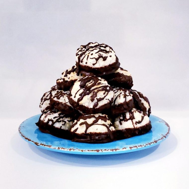 functional image blue plate with towering stack of chocolate dipped and drizzled coconut macaroons white background