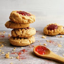 functional image peanut butter and jelly cookies stacked 4 high with a spoonful of jelly