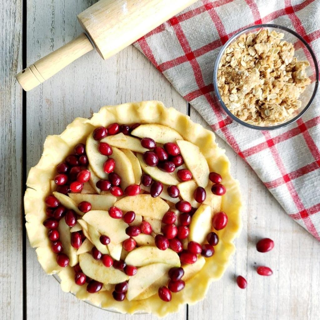 functional image cranberry apple crumble pie recipe unbaked pie with rolling pin and a bowl of crumble