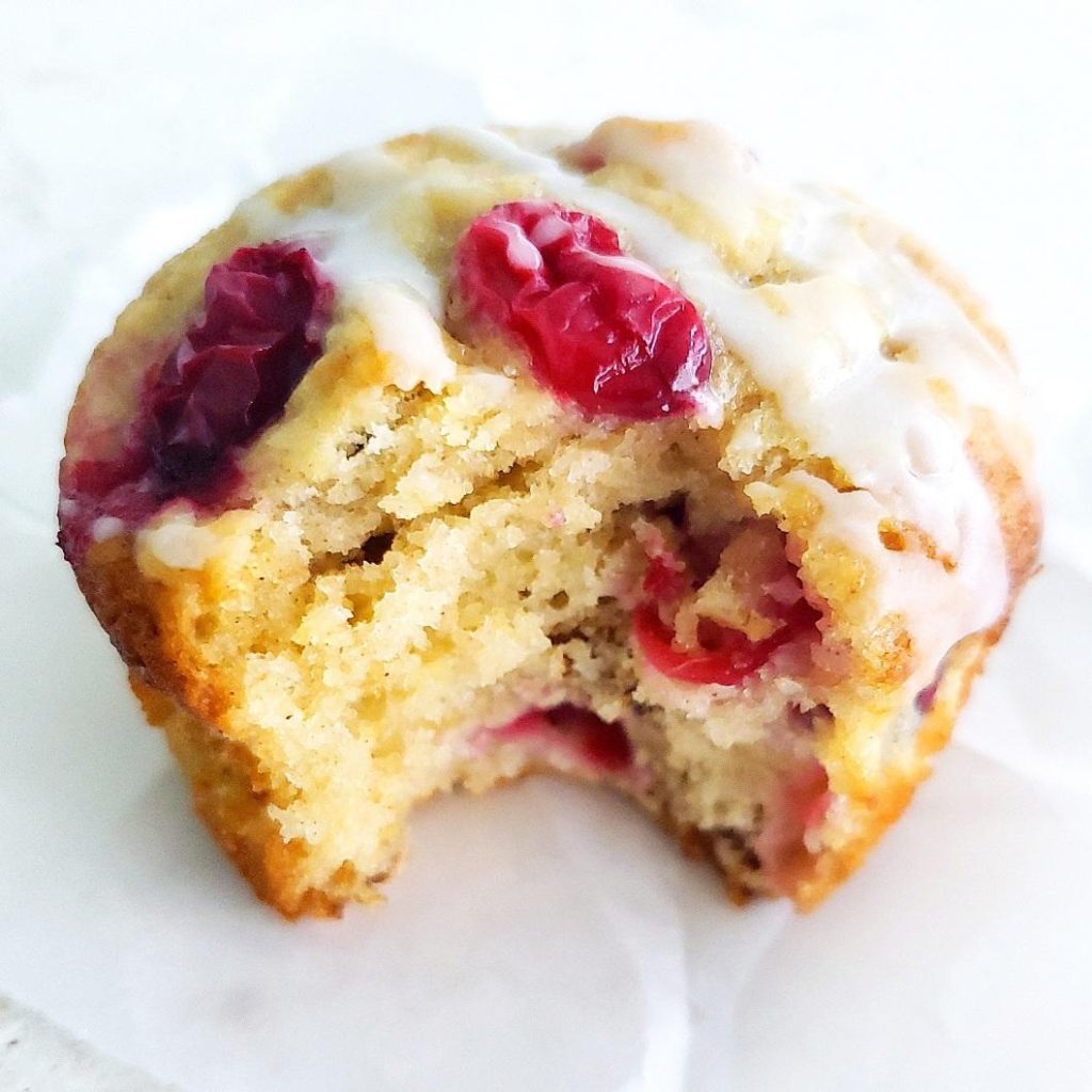 functional image cranberry walnut muffins with sour cream side view of one muffin with a bite out of it