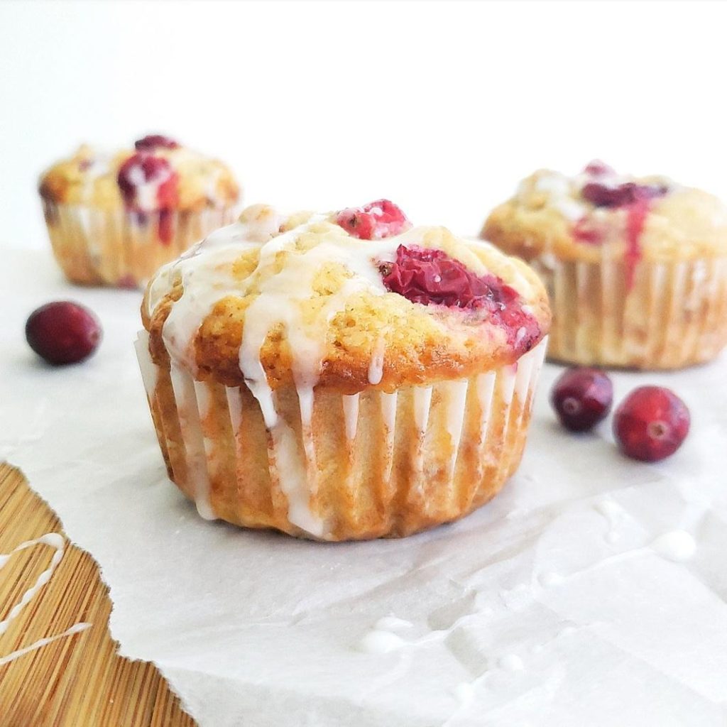 functional image cranberry walnut muffins with sour cream side view on a cutting board with parchment paper 