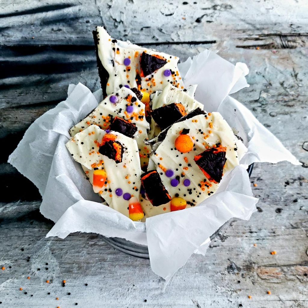 functional image white chocolate halloween oreo bark piled in a clear glass bowl with white parchment