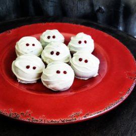 functional image mummy truffles white with red eyes on a red plate with a spooky black background