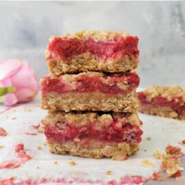 raspberry streusel bars. 3 stack of raspberry crumb bars so you can see the layers of buttery oats and raspberry jam.