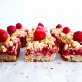 functional image raspberry streusel bars main image side view sliced bars with one fresh raspberry on top of each