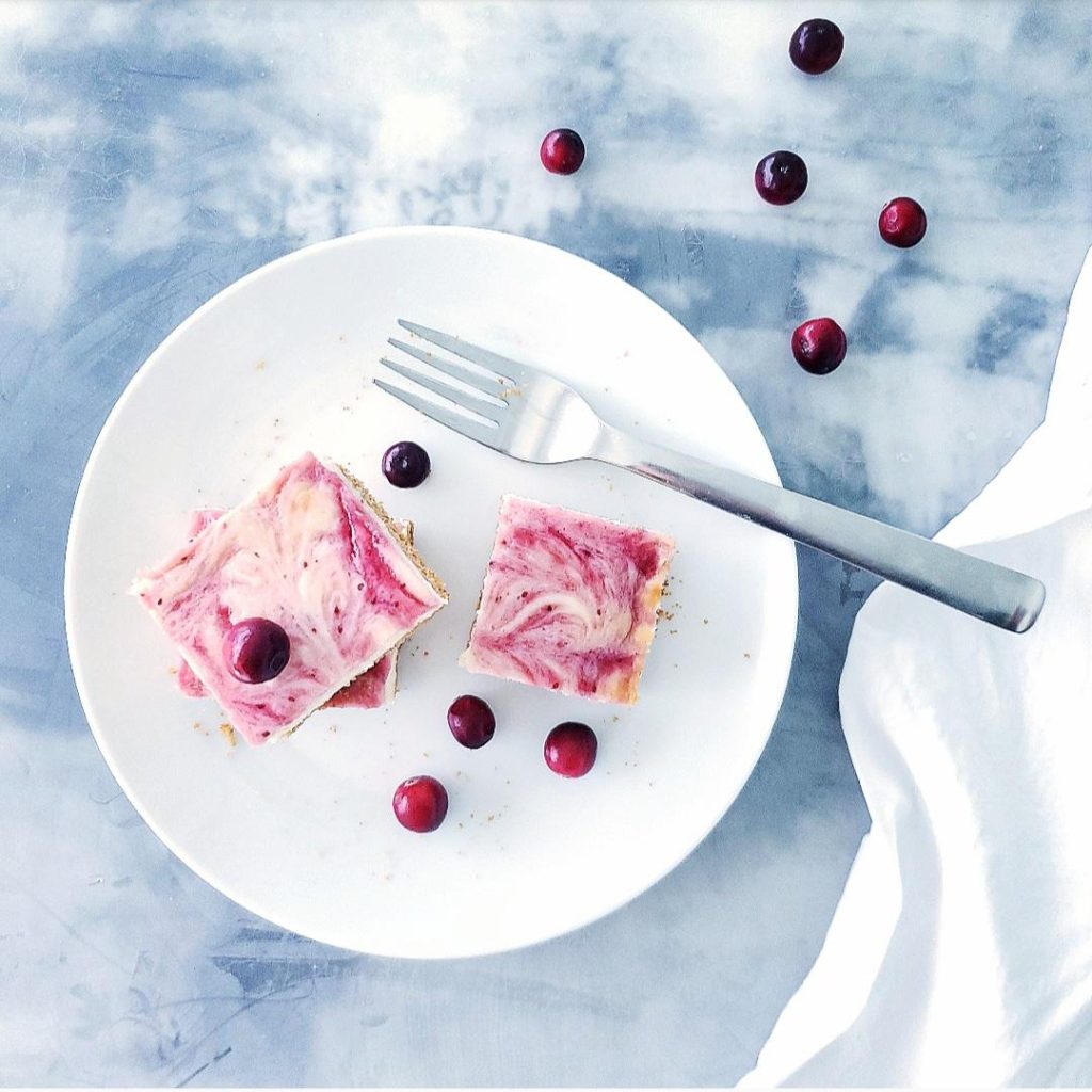 functional image cranberry cheesecake bars with graham cracker crust three on a plate with a fork