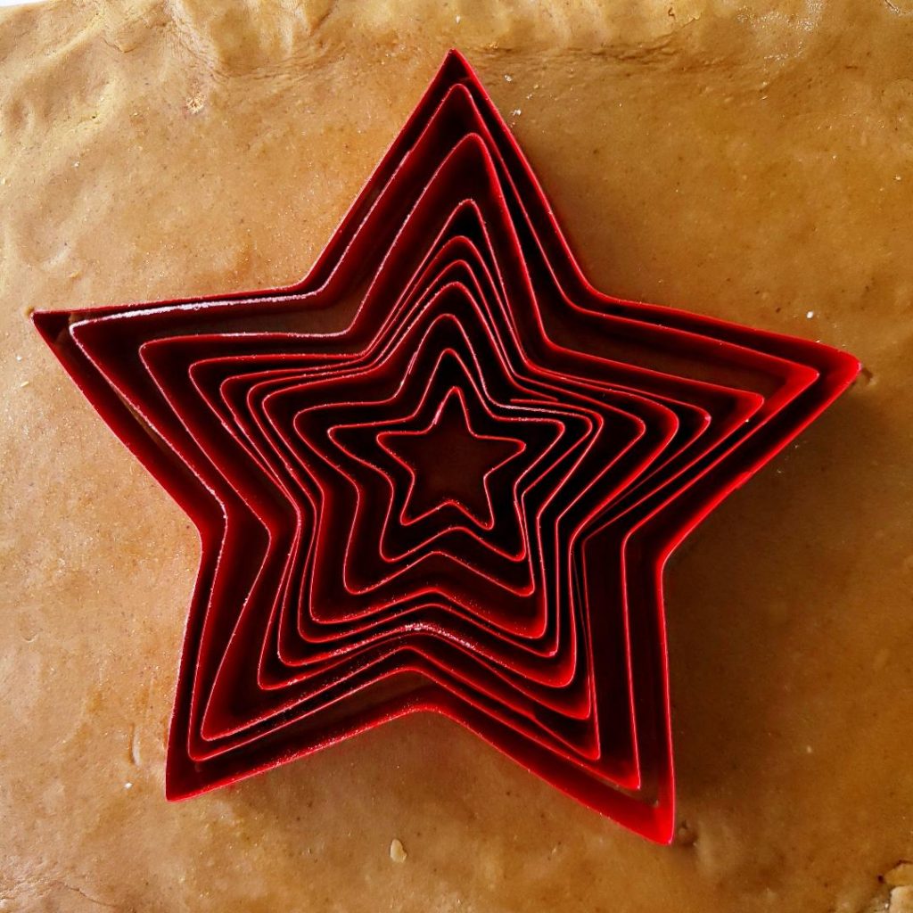 functional image gingerbread star cookie tree cookie cutters on rolled out dough
