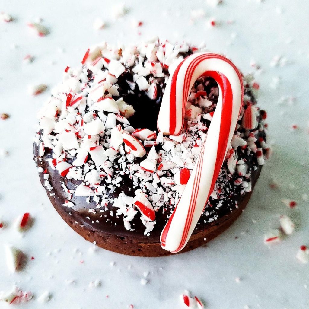 chocolate peppermint donut with peppermint schnapps glaze and crushed candy canes one donut closeup