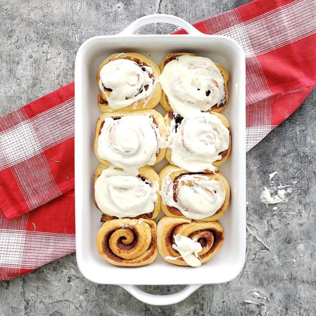 functional image spiked eggnog cinnamon rolls recipe in baking pan with frosting