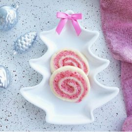 functional image pinwheel cookies with crushed candy canes in a white christmas tree plate with a pink bow