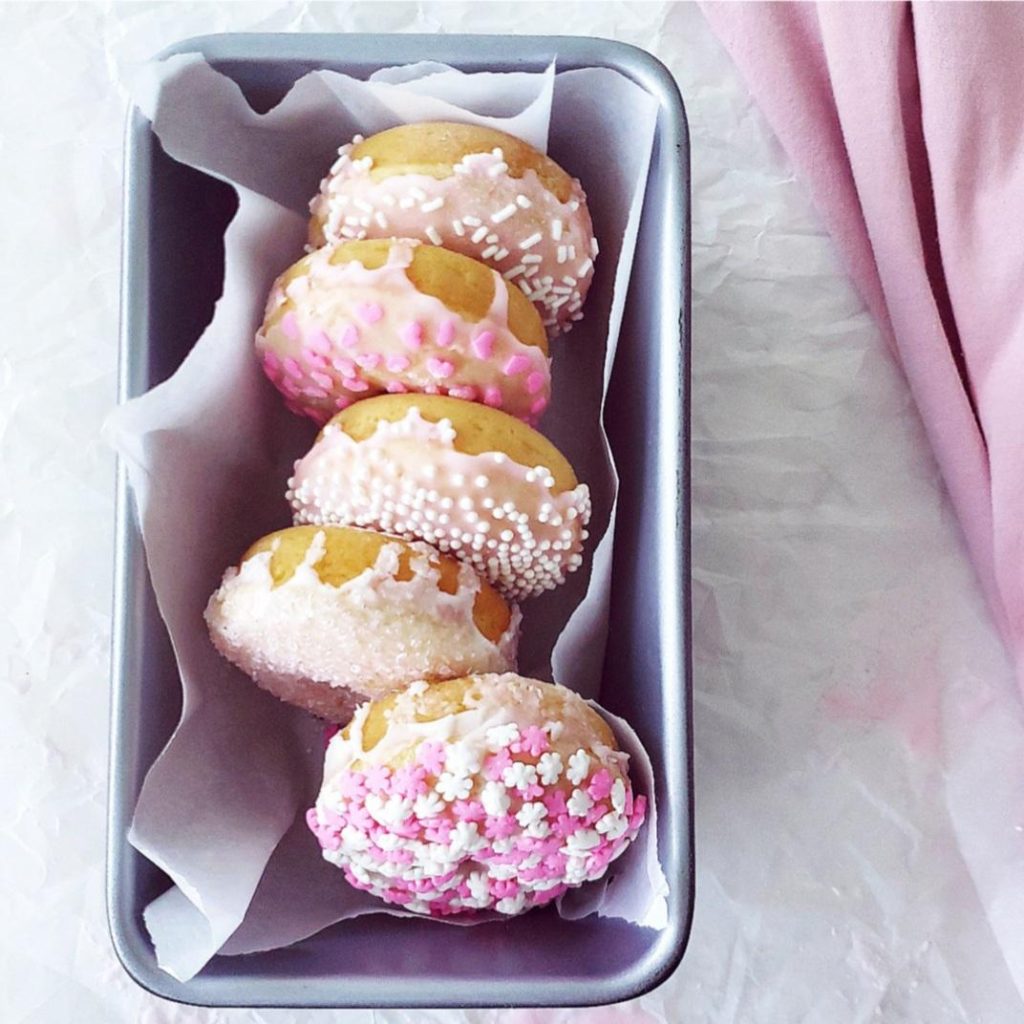 sugar cookie donuts glazed with pink icing and sprinkles in a loaf pan