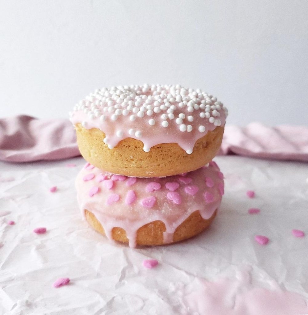pink frosted sugar cookie donuts with sprinkles stacked 2 high