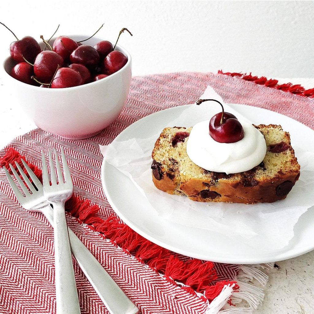 functional image cherry chocolate chp bread quick bread loaf one slice on a plate fresh cherries bing cherries black cherries whipped cream