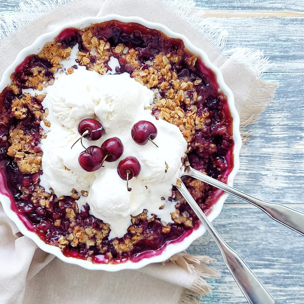 functional image cherry crisp with fresh cherries close up with two spoons and ice cream