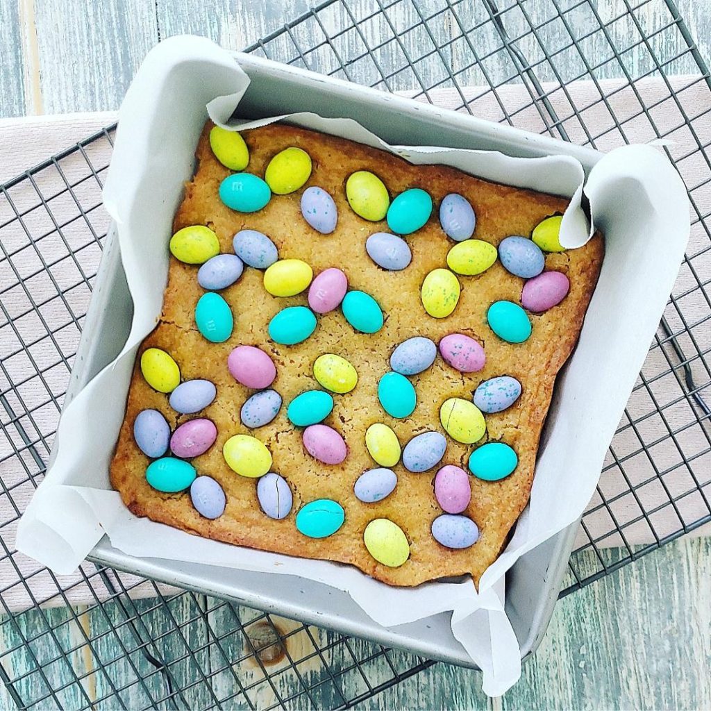 m&m easter blondies top down view of blondies topped with pastel m&m eggs. 