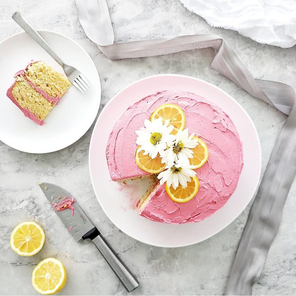 functional image southern lemon cake with blackberry buttercream frosting one slice plated daisies 