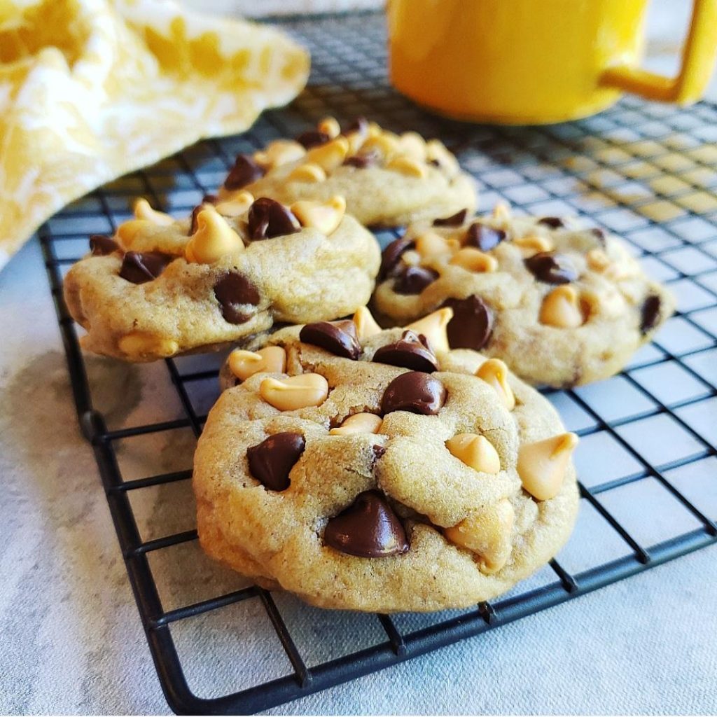 functional image chocolate chip butterscotch cookies close up of four cookies on a baking rack with a yellow coffee mug in the background