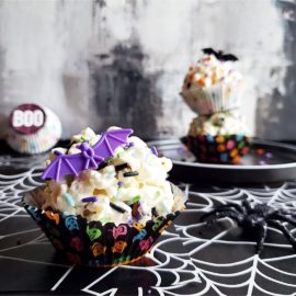 functional image halloween popcorn balls one in front with a purple bat and two stacked in backgound