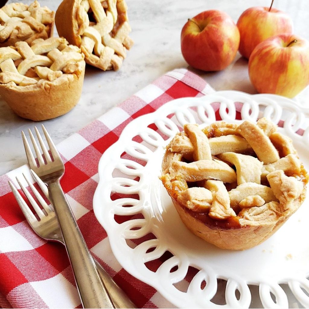 functional image jumbo muffin tin apple pie on a white plate with a red napkin forks and fresh apples
