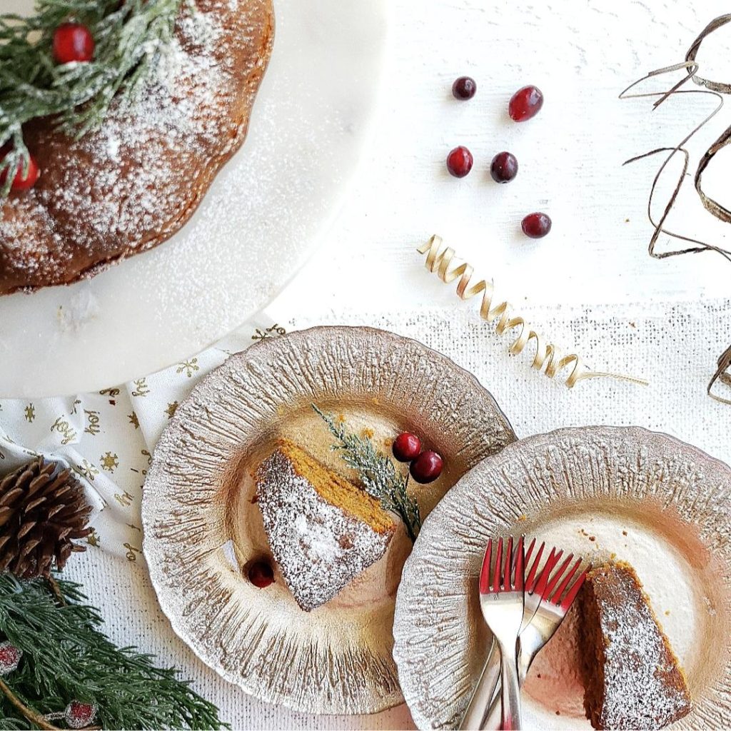 functional image gingerbread bundt cake with powdered sugar. two slices on gold plates top down photo