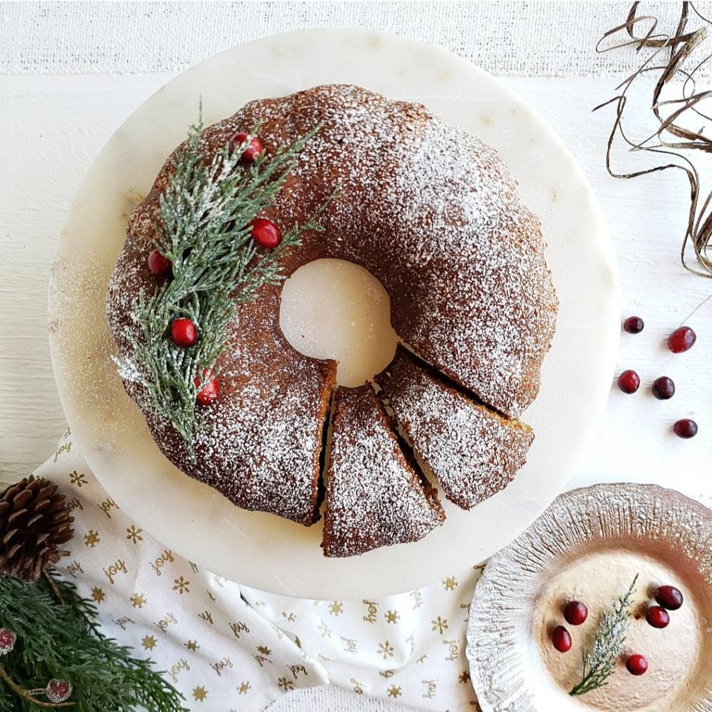 functional image gingerbread bundt cake for christmas top down photo two slices cut with greenery and fresh cranberries