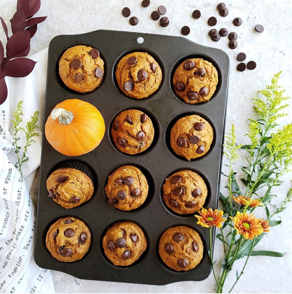 functional image pumpkin muffins with chocolate chips in a muffin pan with a mini pumpkin