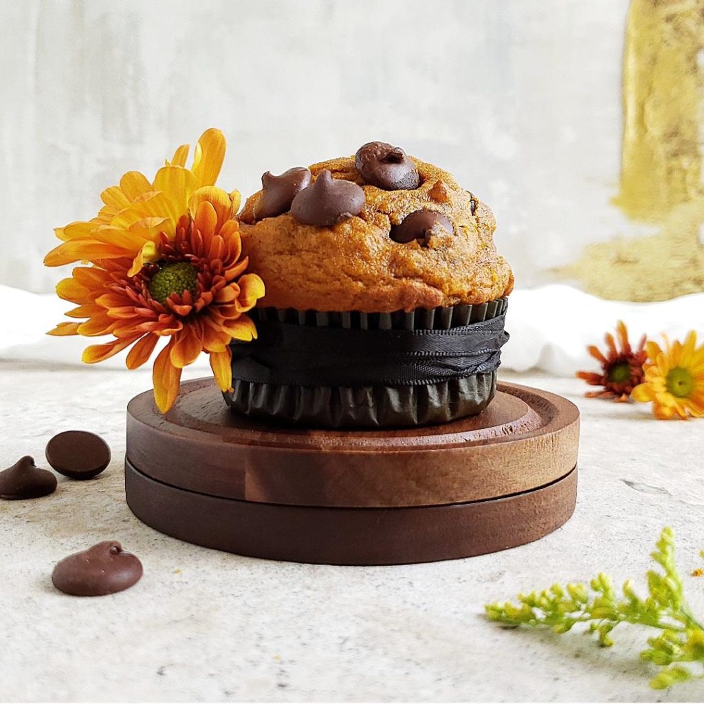 functional image pumpkin chocolate chip muffin black ribbon tied around it holding orange flowers