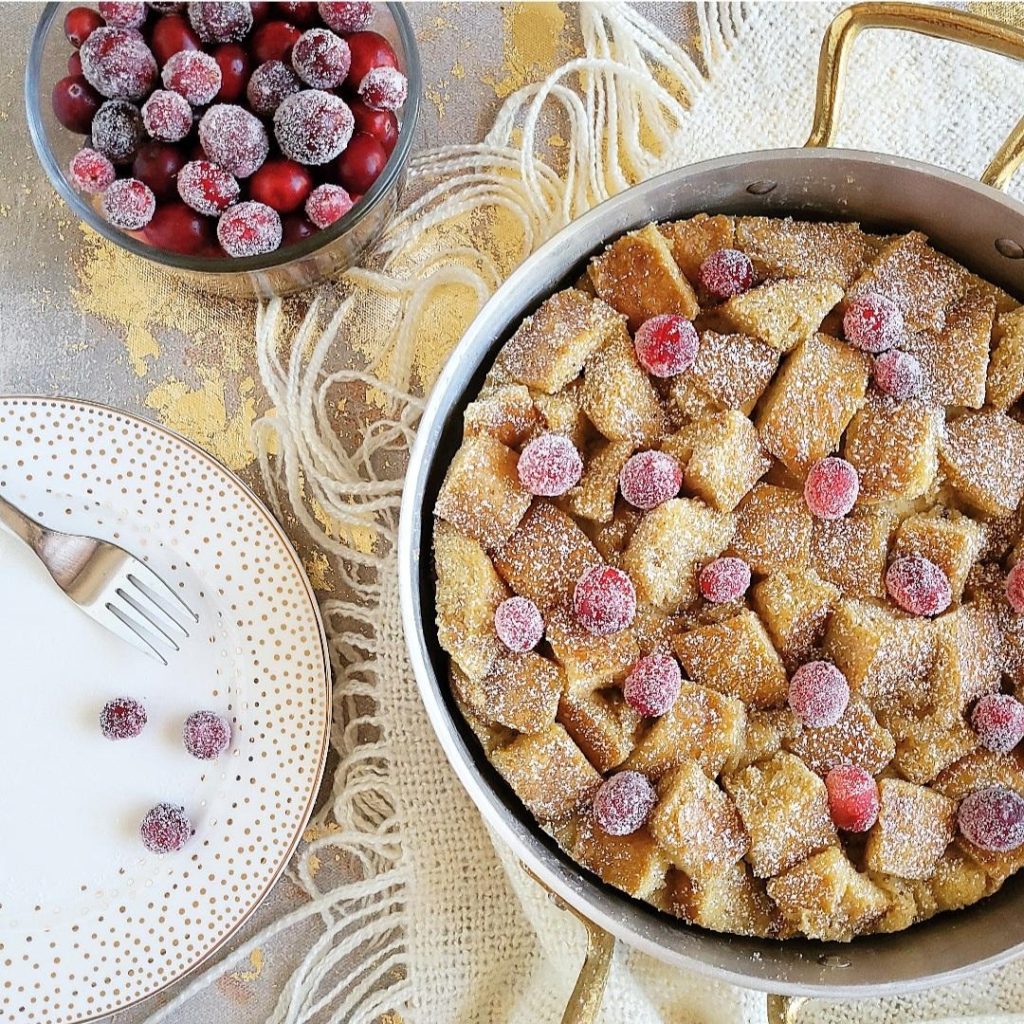 functional image eggnog bread pudding top down image of dessert in an aluminum pan and a gold polka dot plate to the left