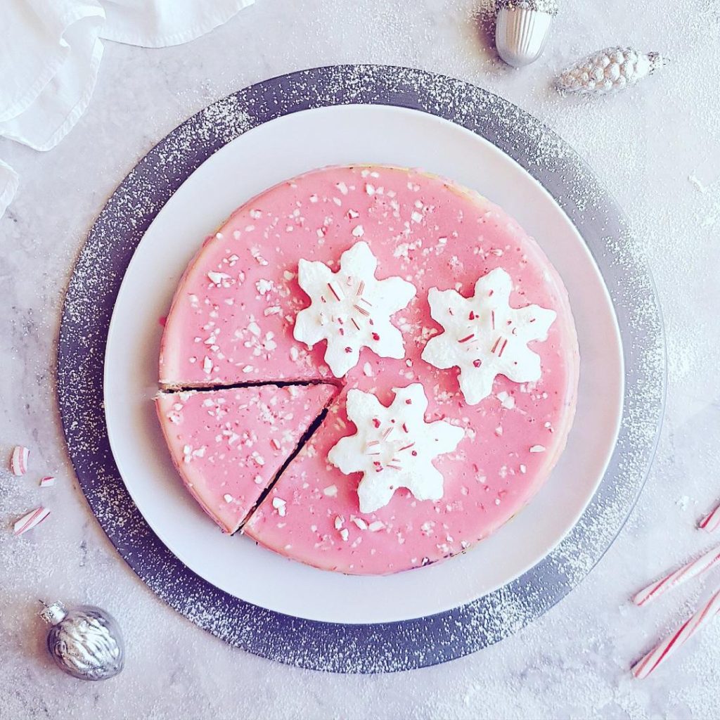 functional image peppermint cheesecake top down with one slice cut and snowflake marshmallows christmas cheesecake holiday dessert