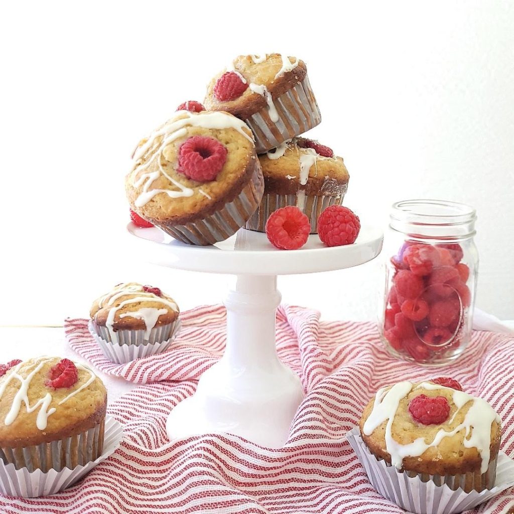 functional image white chocolate raspberry muffins on a mini cake stand and a red and white striped linen side view