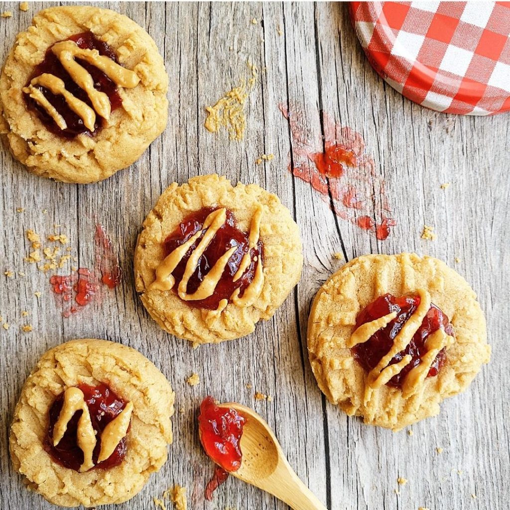 functional image peanut butter and jelly  cookies peanut butter thumbprints pbj cookies top down with peanut butter drizzle