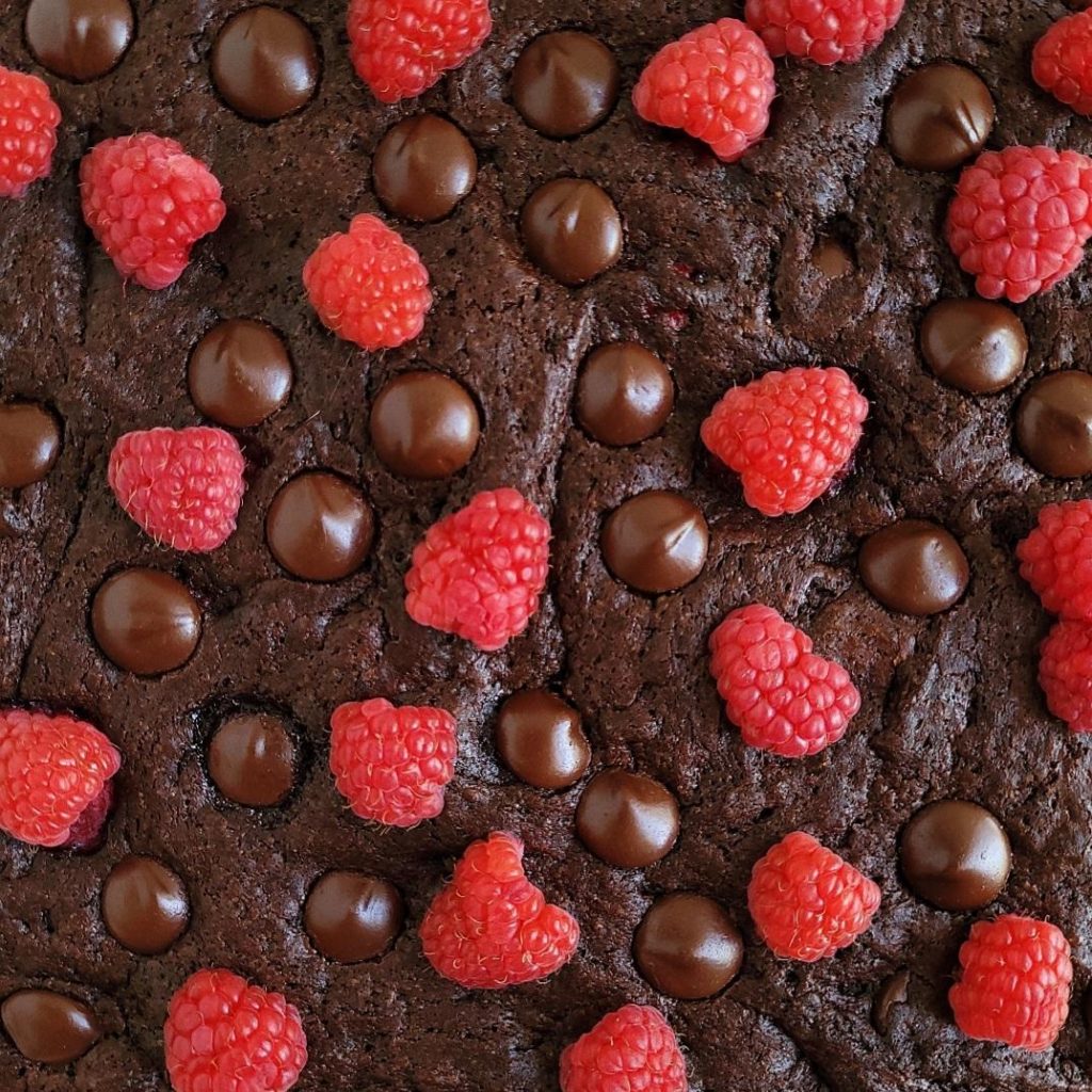 functional image raspberry brownies top down closeup of uncut brownies with chocolate chips and fresh raspberries