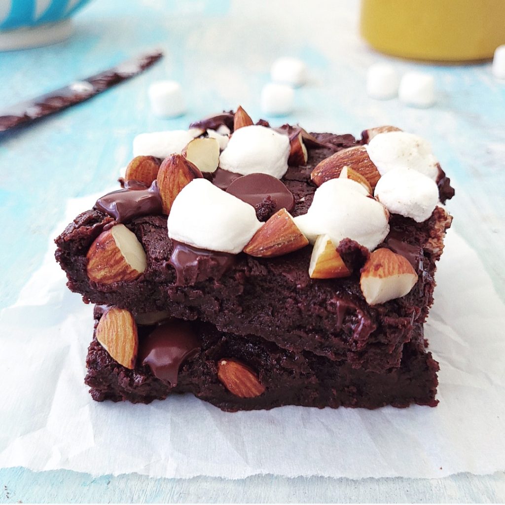 functional image rocky road brownies two squares cut and stacked with mini marshmallows, chopped almonds and melty chocolate chips