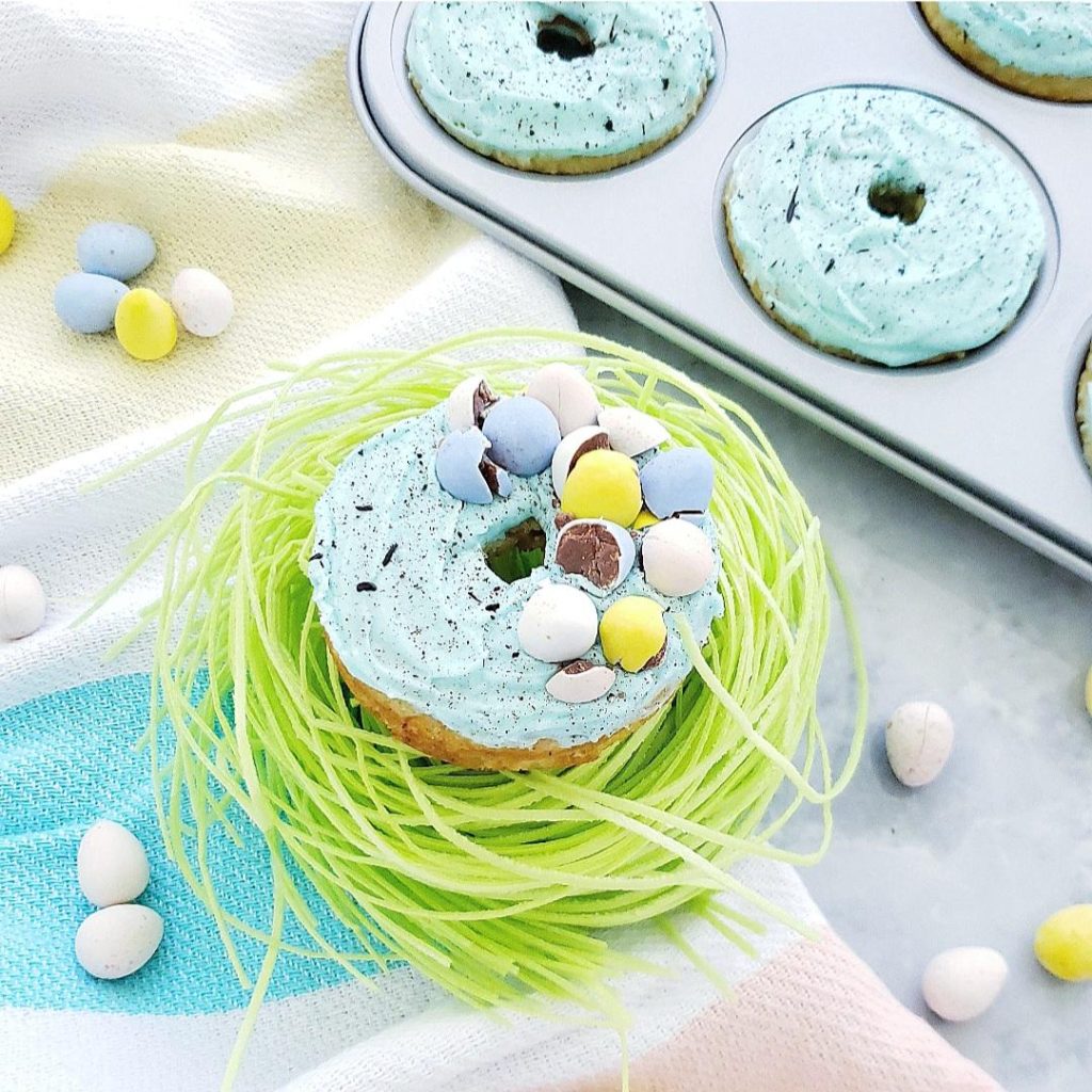 mini egg easter donuts robins egg blue frosting topped with crushed cadbury mini eggs and sitting on edible easter grass