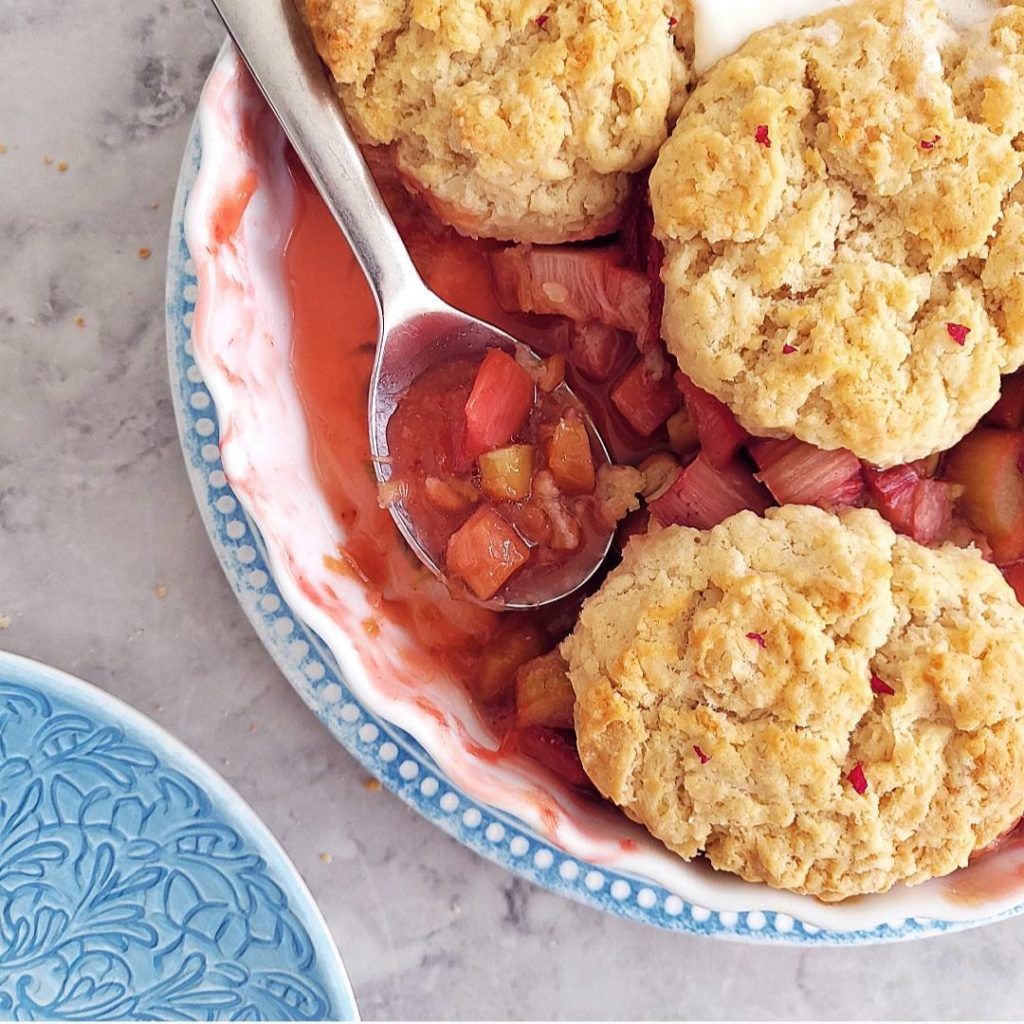 functional image strawberry rhubarb cobbler close up of a spoon in the fruit filling