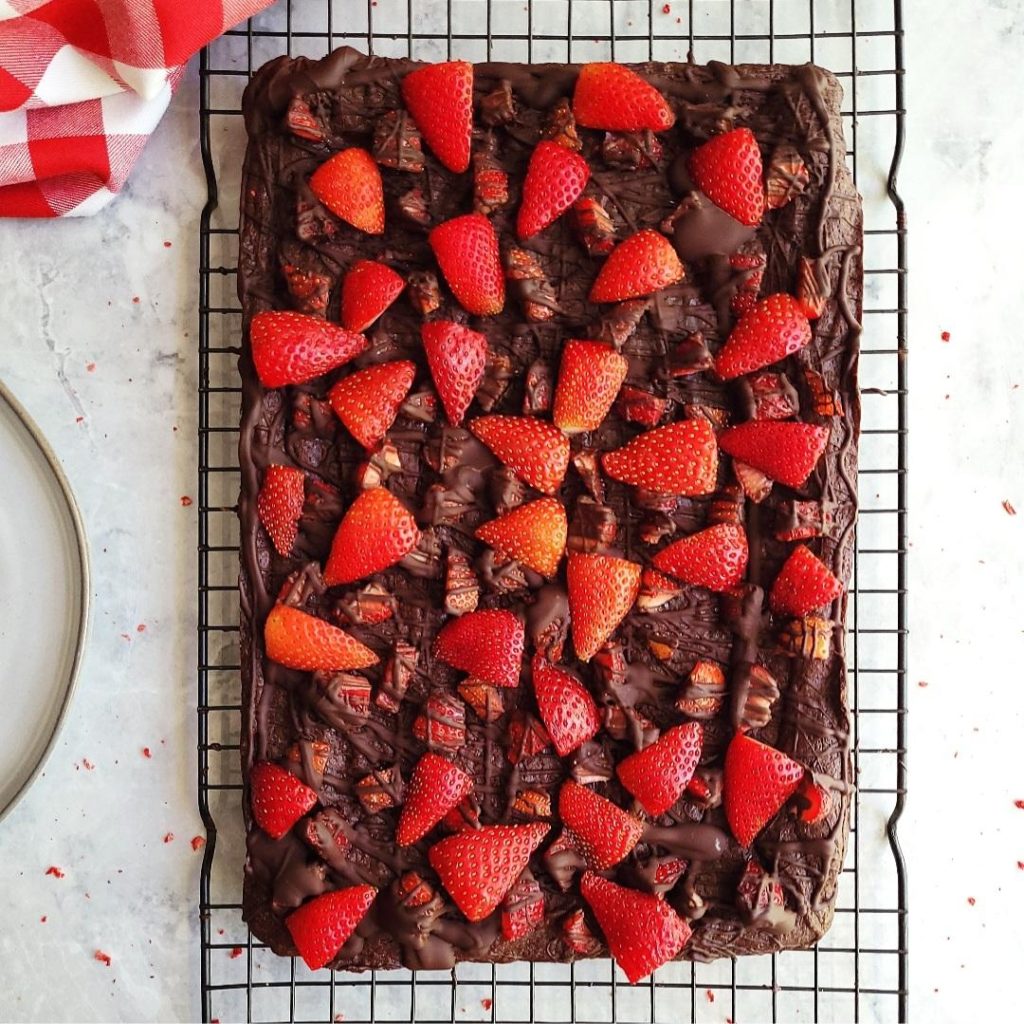 functional image chocolate covered strawberry brownies top down view uncut with fresh strawberries and a black wire baking rack