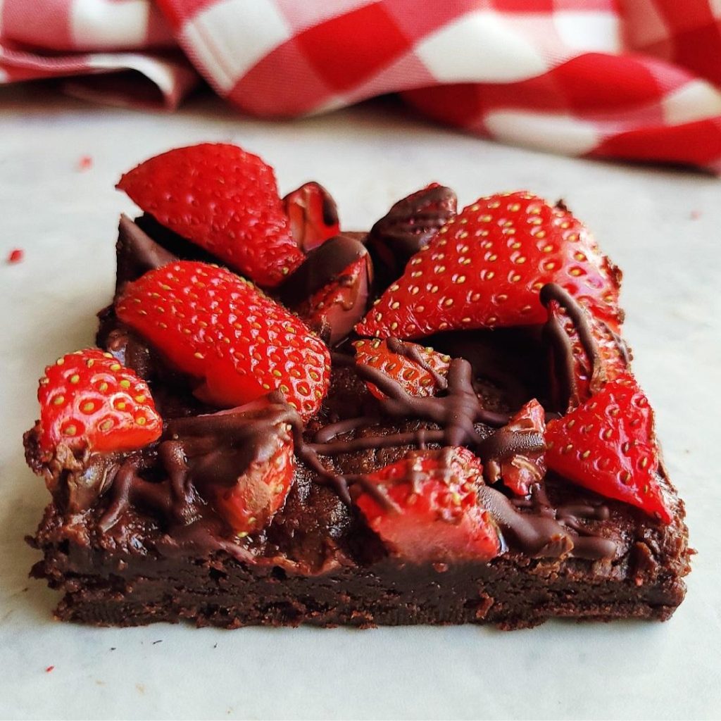 functional image strawberry brownies close up of a singe slice topped with fresh strawberries 
