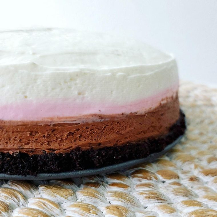 functional image neapolitan cheesecake cup close view of oreo crust chocolate cheesecake layer strawberry cheesecake layer and vanilla cheesecake layer