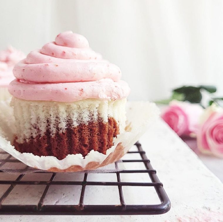 neapolitan cupcakes on a wire rack cupcake liner removed strawberry frosting on a vanilla and chocolate cupcake