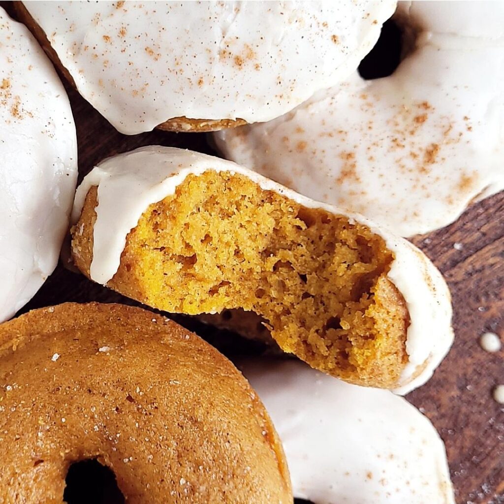 functional image pumpkin donuts top down zoomed in on a donut with a bite missing to see the orange crumb