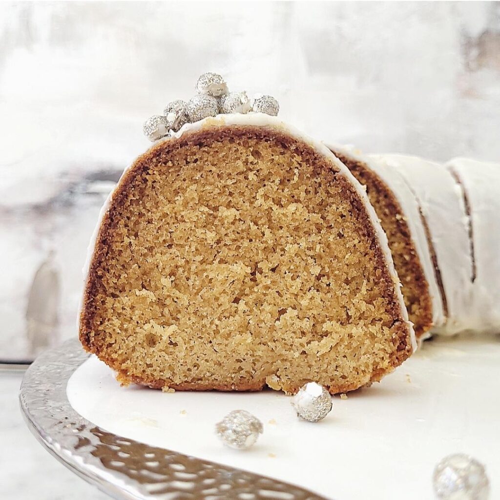 eggnog bundt cake close up view of moist crumbs from a slice on the silver rimmed cake plate