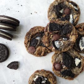 oreo chocolate chip cookies on a white surface top down view of pile of cookies next to oreo cookies