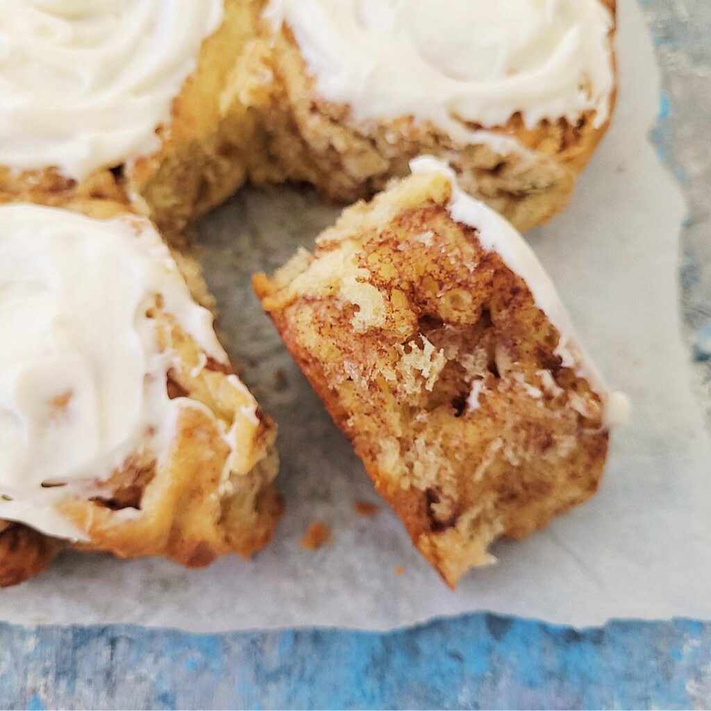 soft and fluffy cinnamon rolls. close up view of a cinnamon roll tipped on its side so you can see the brown sugar and cinnamon center. 