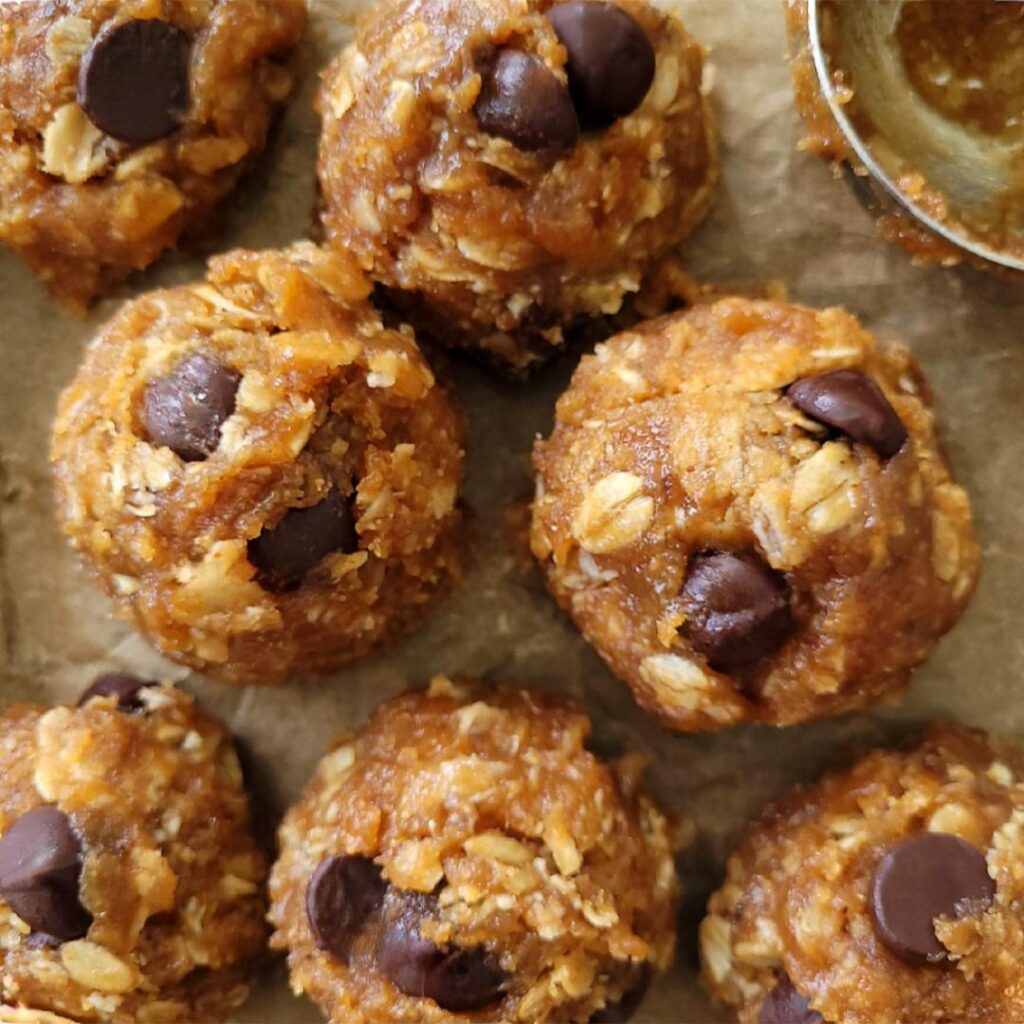 peanut butter banana oatmeal cookies. top down view of cookie dough balls with dark chocolate chips. 