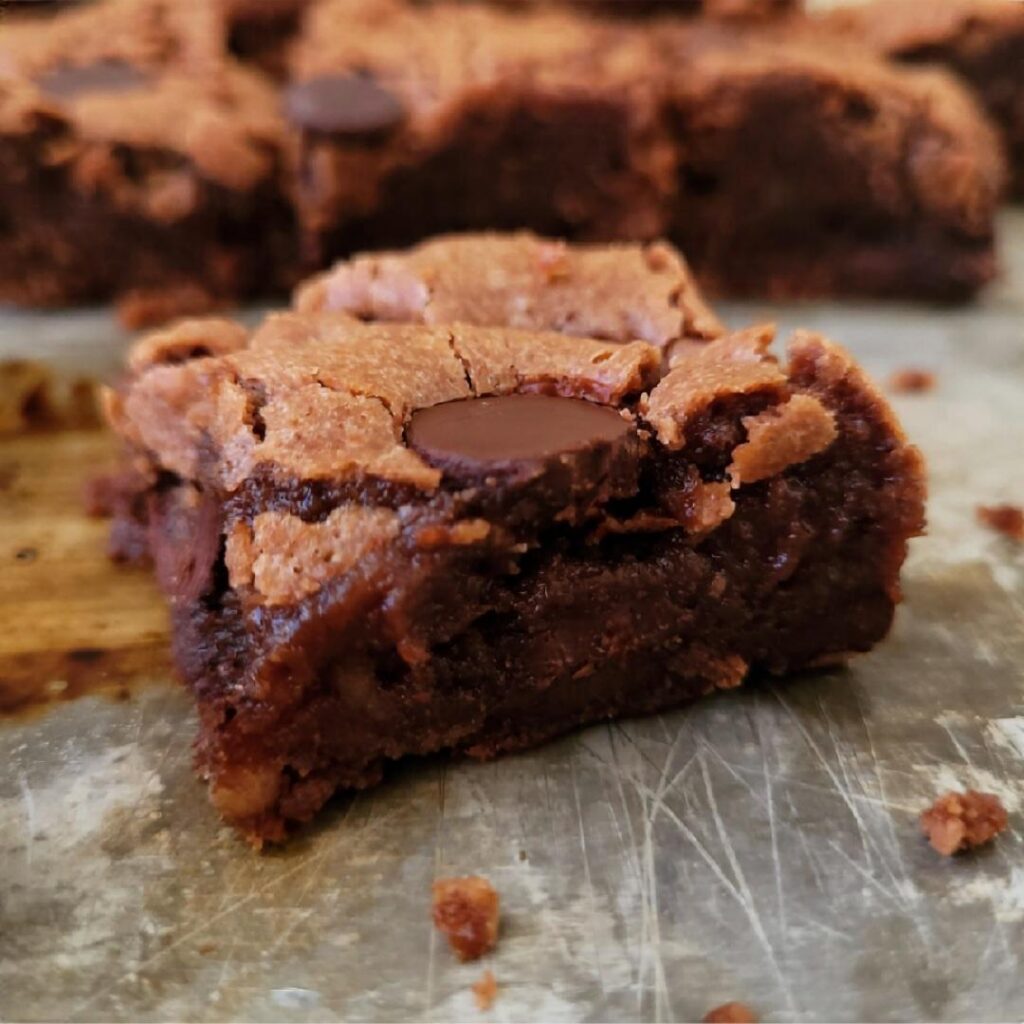 banana brownies. close up side view of one slice cut into a square so you can see the fudgy brownie crumbs inside. 